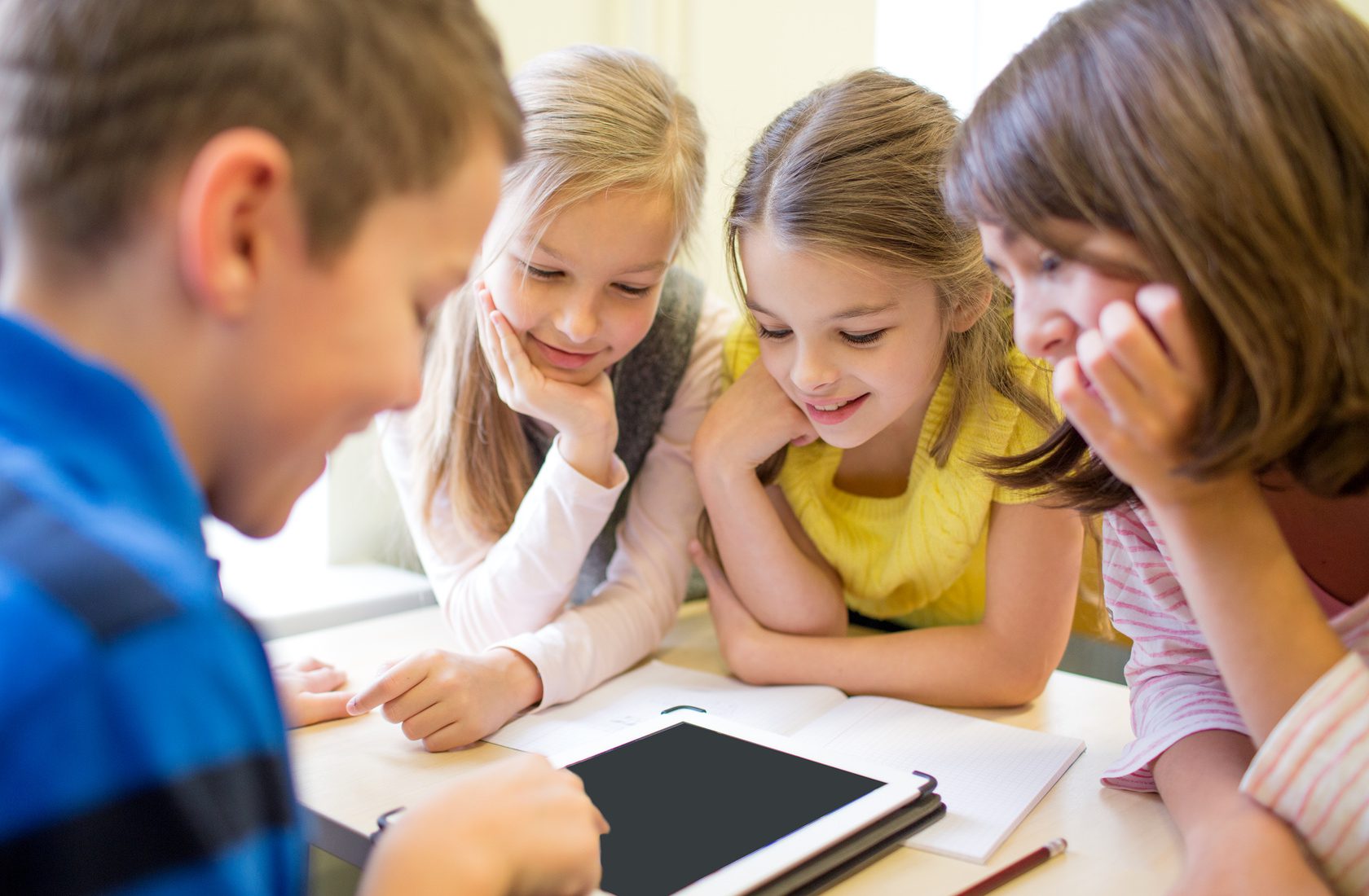 education, elementary school, learning, technology and people concept - group of school kids with tablet pc computer having fun on break in classroom